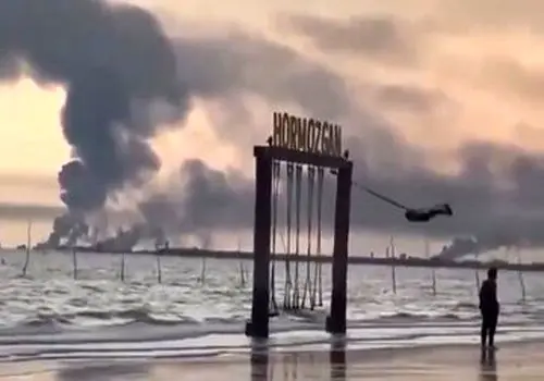 لحظه تاب‌بازی یک کودک در سواحل جنوب زیر سایه دود انفجار وایرال شد+‌  فیلم
