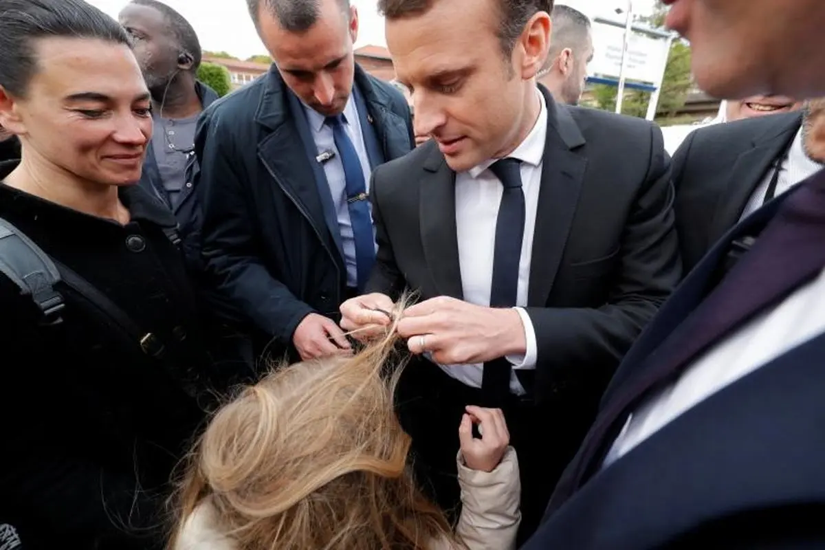 گیرکردن موی بلند یک دختربچه به دکمه کت نامزد ریاست جمهوری فرانسه