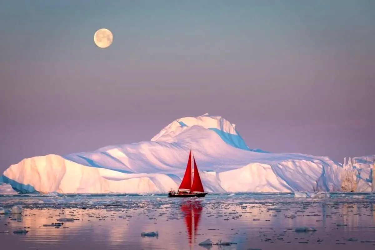 قایق بادبانی در برابر کوه یخ+عکس