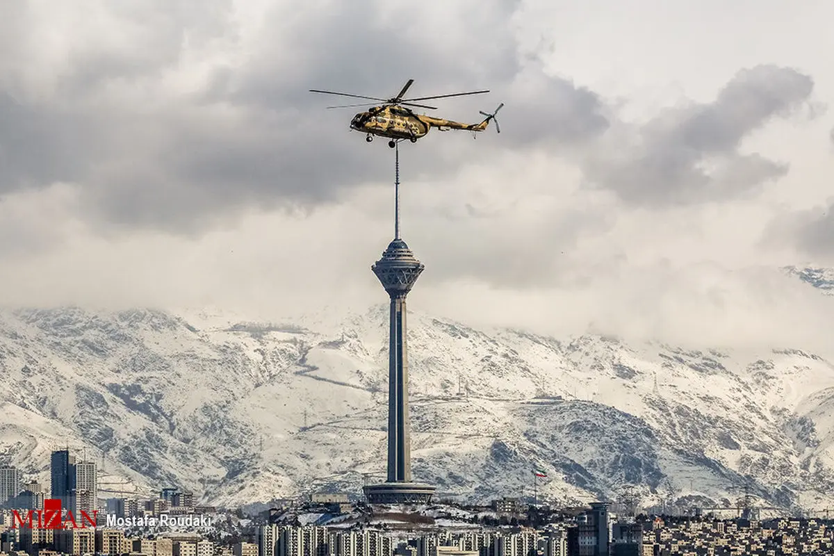 تقارن دیدنی هلی‌کوپتر با برج میلاد در یک روز برفی+عکس