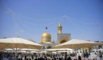 تعویض پرچم گنبد مطهر امام هشتم (ع)/عکس