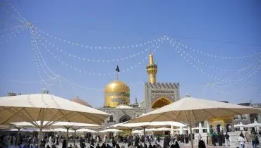 تعویض پرچم گنبد مطهر امام هشتم (ع)/عکس