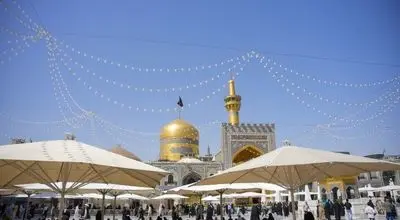 تعویض پرچم گنبد مطهر امام هشتم (ع)/عکس