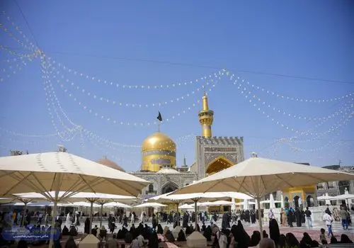 تعویض پرچم گنبد مطهر امام هشتم (ع)/عکس