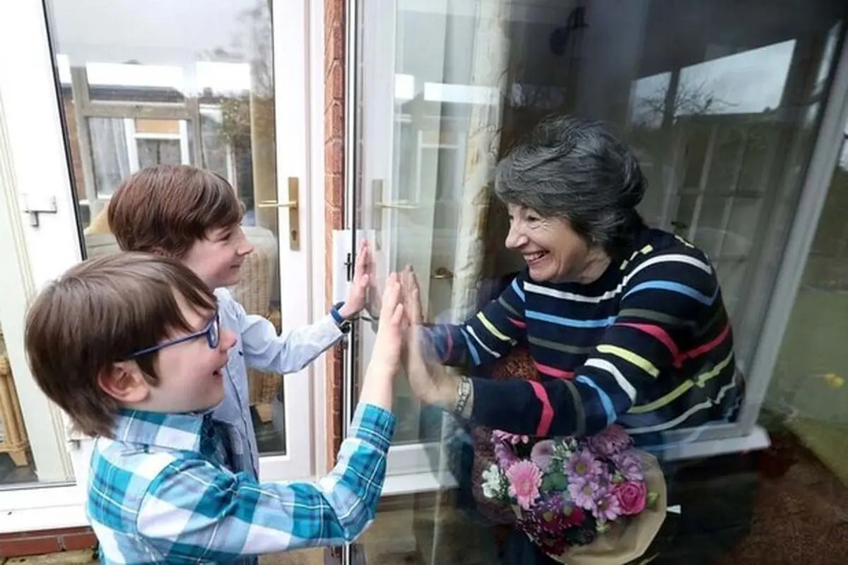 دیدار مادر بزرگ انگلیسی با نوه‌ها از پشت پنجره + عکس
