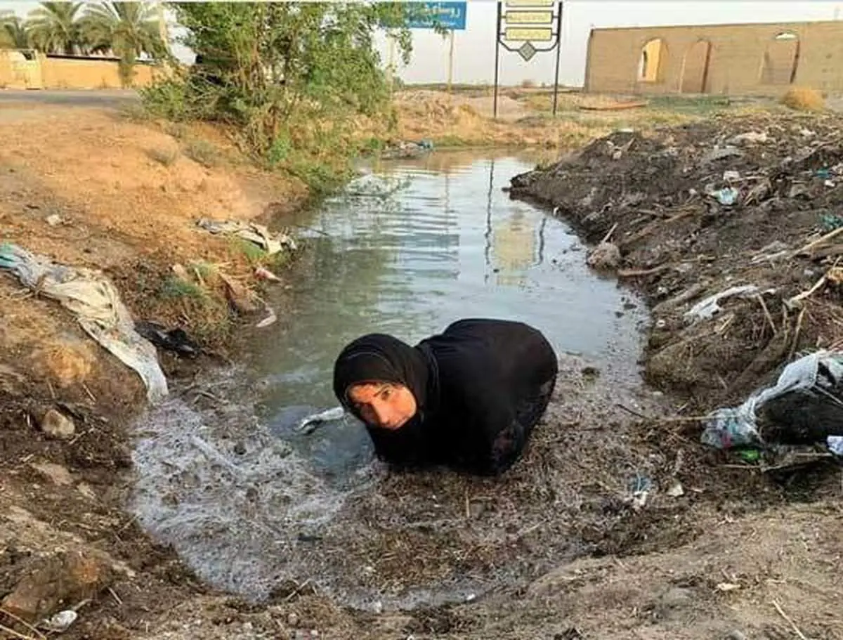 تصویر تکان دهنده از زن خوزستانی برای رسیدن آب به مزرعه اش+عکس