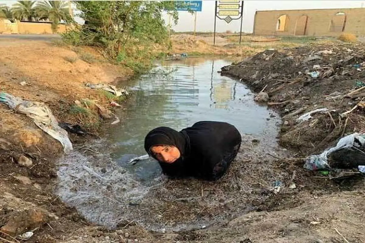 تصویر تکان دهنده از زن خوزستانی برای رسیدن آب به مزرعه اش+عکس