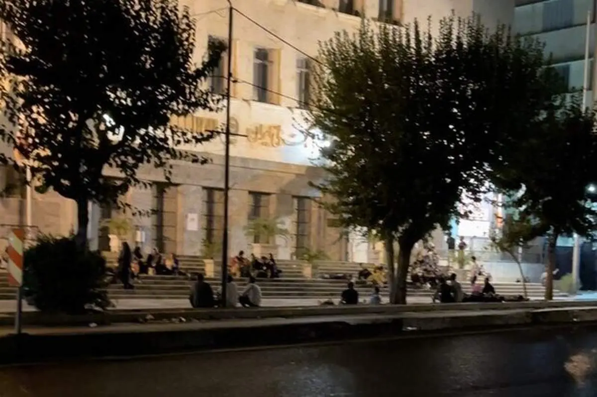 ازدحام شبانه مهاجران افغان روی پله‌های بانک ملی در تهران + فیلم
