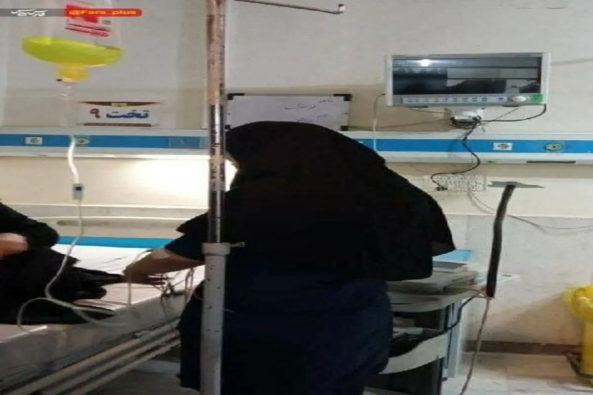 تصویری تکان دهنده از پرستاری که با سرم به دست به حال بیماران رسیدگی میکند
