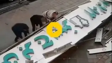 لحظه هولناک سقوط تابلوی تبلیغات یک مغازه روی سر رهگذر در تهران+ فیلم