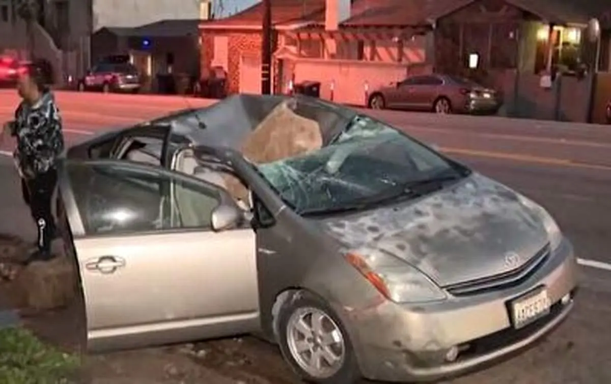 سقوط ناگهانی یک تخته سنگ روی سقف خودرو!+ فیلم